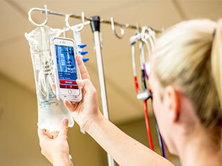 A nurse scanning an IV bag with a mobile app